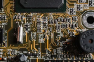 Close-up of a green circuit board with chips and printed labels