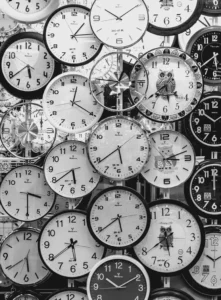Many wall clocks showing different times