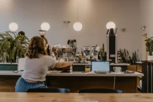 Person working on a laptop at a counter in a cafe
