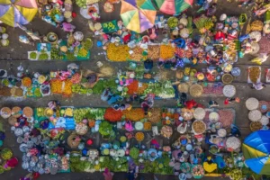 Aerial view of a busy outdoor market with stalls and shoppers