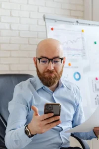 Man looking at his smartphone with a puzzled expression