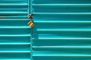 Gold padlock on a blue metal shutter door