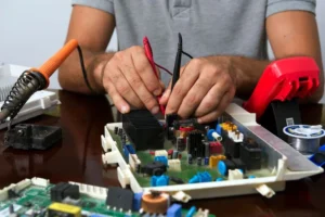 Technician testing a circuit board with meter probes at a workbench