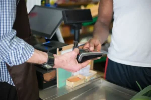 Customer paying with a card at a shop counter payment terminal