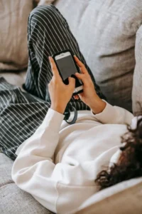 Woman resting on a sofa using a smartphone