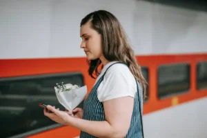 Traveller at a train platform using a phone while waiting